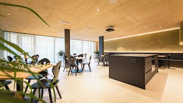 Un espace de bureau moderne doté d’un îlot central, de tables rondes et de chaises.