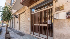 A building with a closed metal gate and a sign indicating a technical studio.