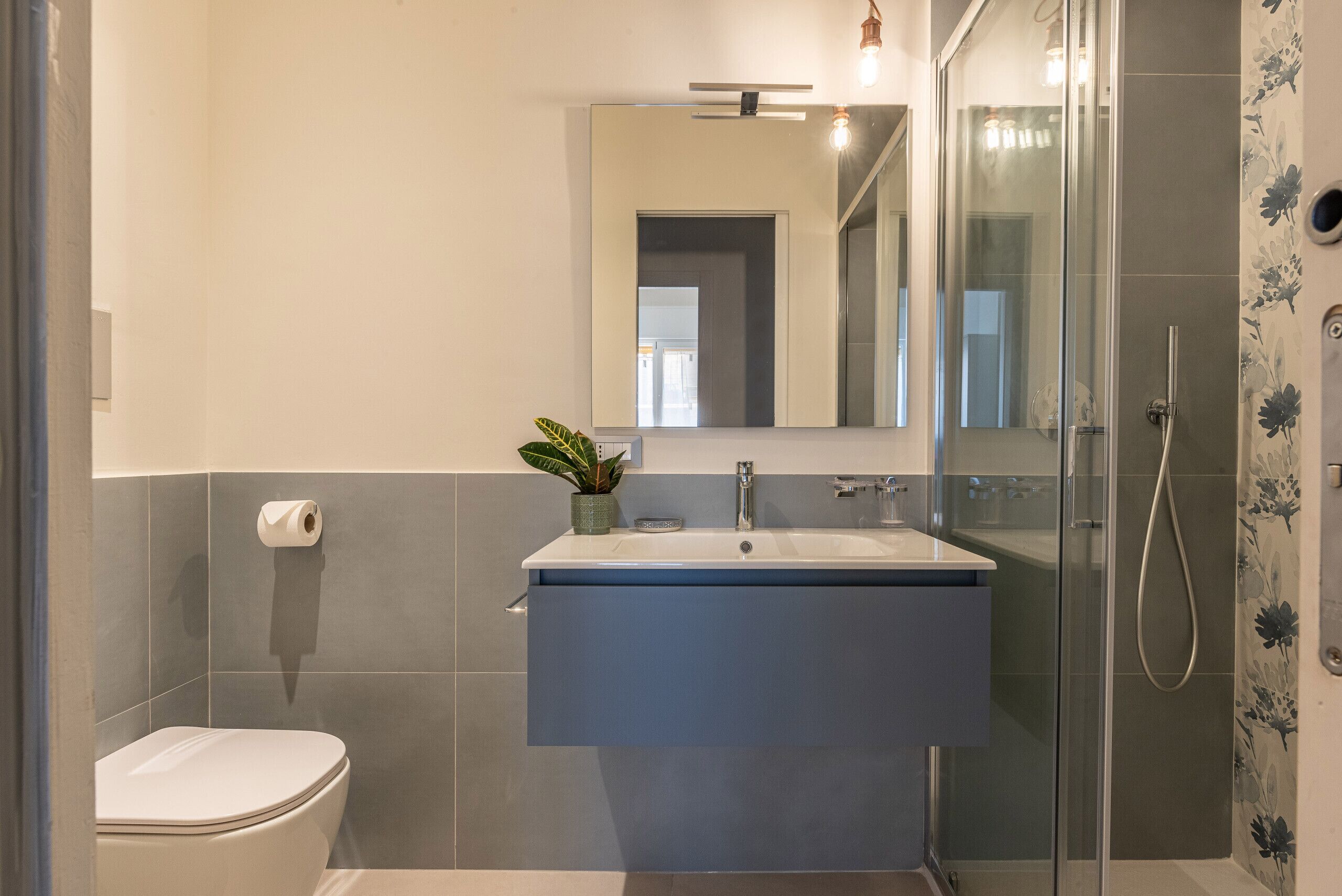 Een moderne badkamer met toilet, wastafel en douche.