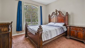A bedroom with a large bed, a dresser, and a window with curtains. - Tremendous Family Home on the Curve! 3-bedrooms close to the lake and amenities (Brookeland)