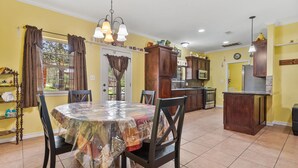 A dining area with a round table covered in a patterned tablecloth, surrounded by chairs. - Tremendous Family Home on the Curve! 3-bedrooms close to the lake and amenities (Brookeland)