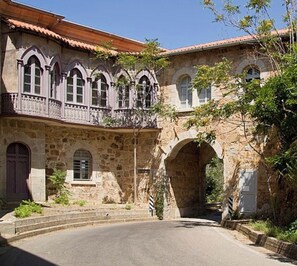 A stone building with arched windows and a balcony.