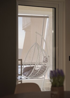 Una habitación con una silla colgante cerca de una ventana.