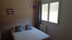 A room with a bed, a window with blinds, and a wall-mounted picture. - Vacation Home (Montmeyan)