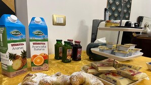 Una mesa de desayuno con pasteles, zumos envasados y recipientes de yogur.
