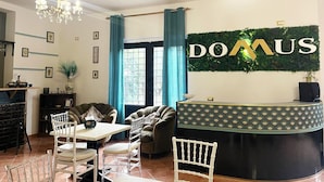Un área de recepción de diseño moderno, con mostrador de recepción, zona de estar y una araña.