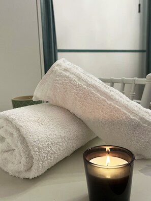 A white towel and a candle on a table. - Domus Tuscia (Viterbo)