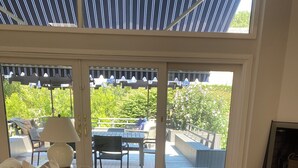 Una sala de estar moderna con un sofá, una mesa de centro y vistas al área del patio exterior.