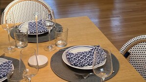 Amplia sala de estar con una mesa de comedor lista para seis personas, un sofá y una mesa de centro con lámparas.