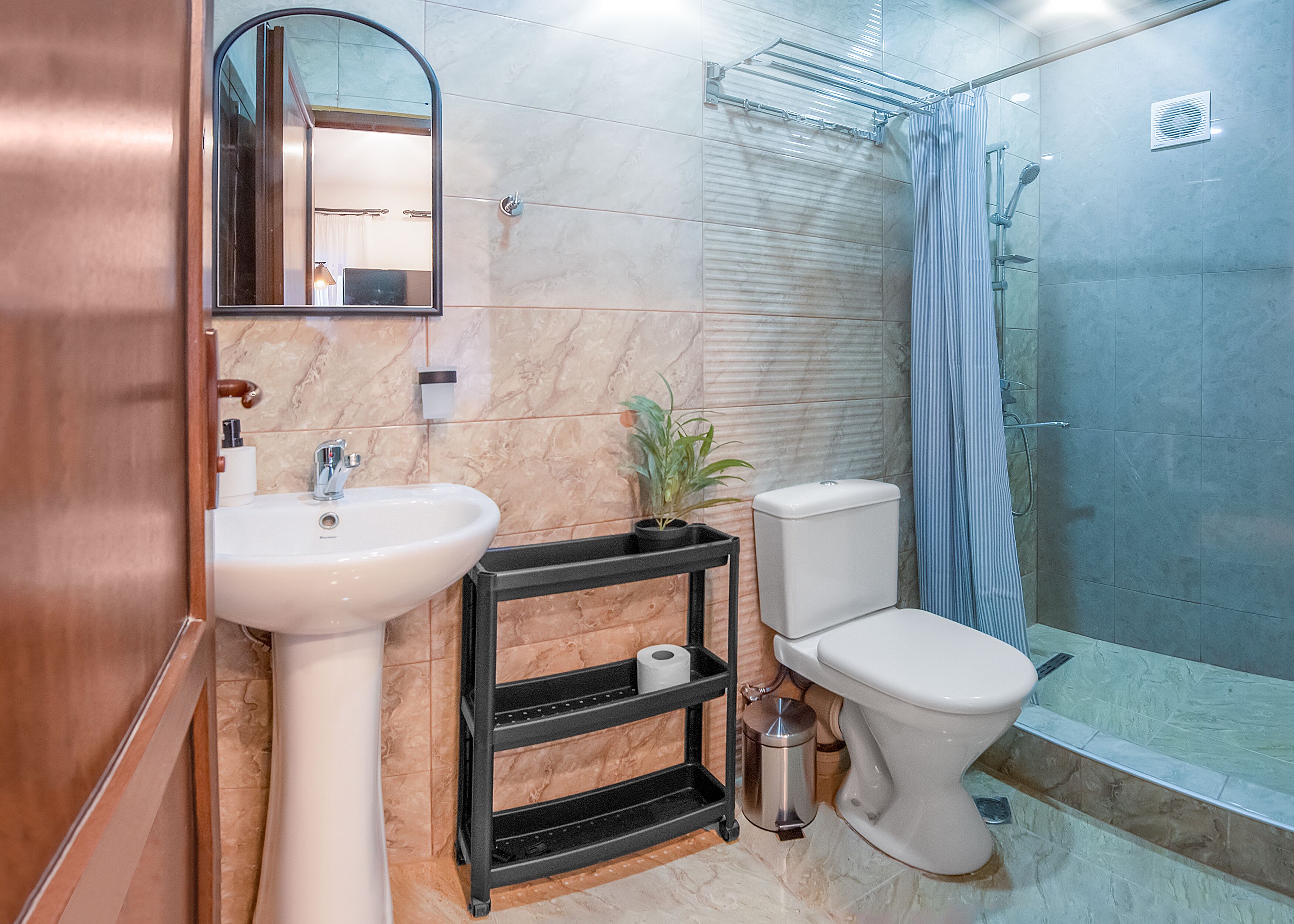 A bathroom with a sink, toilet, shower, and a mirror.