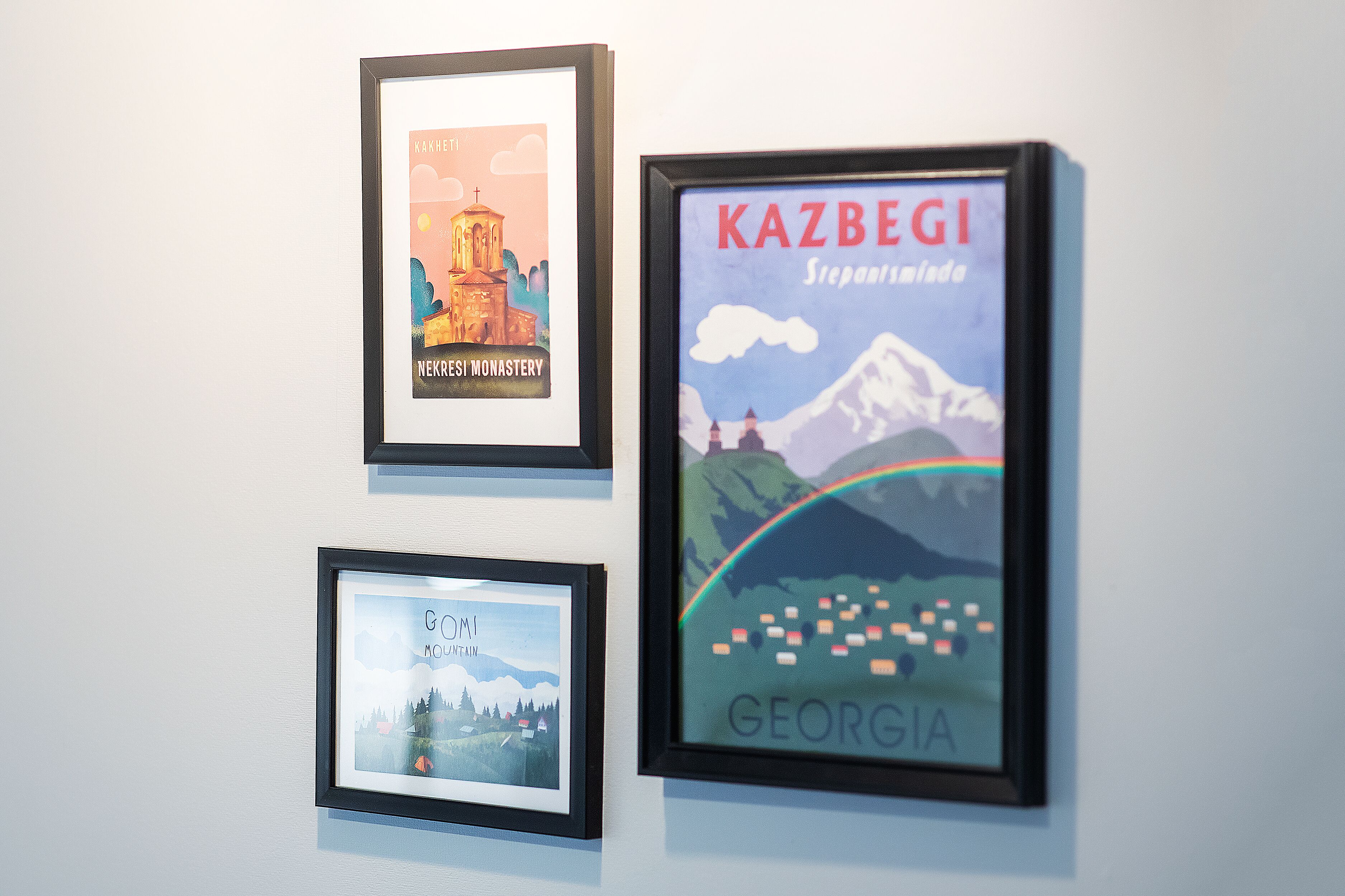 Three framed artworks on a wall.