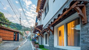 Una estrecha calle adoquinada bordeada por edificios tradicionales con balcones de madera y fachadas de piedra.