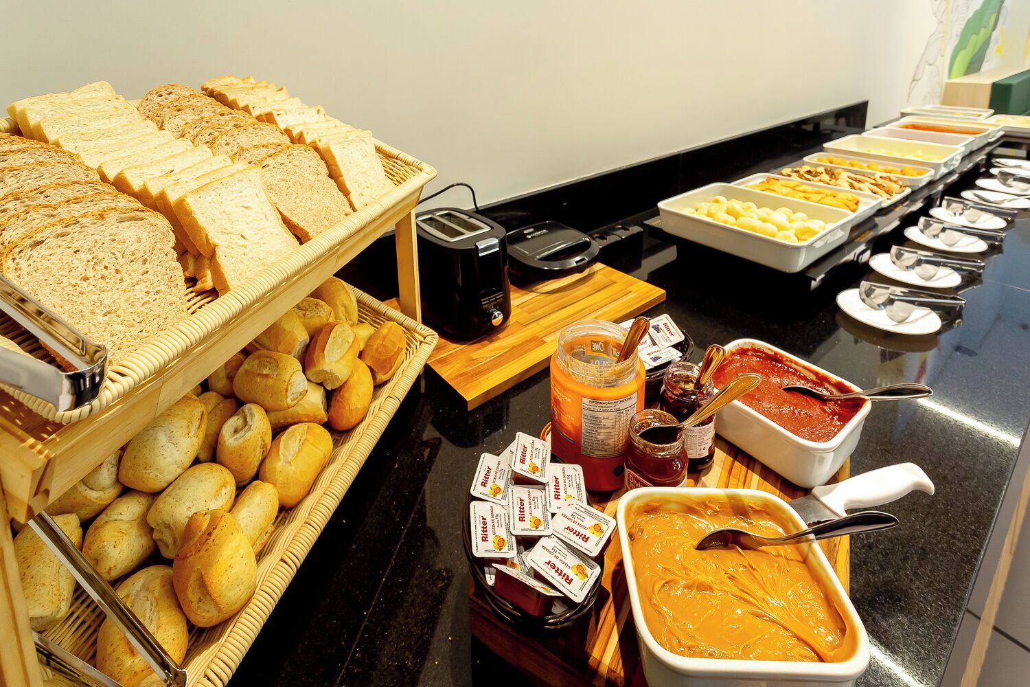 A buffet with bread, pastries, jams, and spreads.