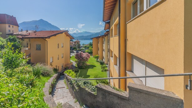 A residential building with a view of a lake and mountains in the background.