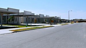 A modern building with a covered walkway and a parking lot. - Elegant Apartment 10 min to Mercedes Outlets (Weslaco)