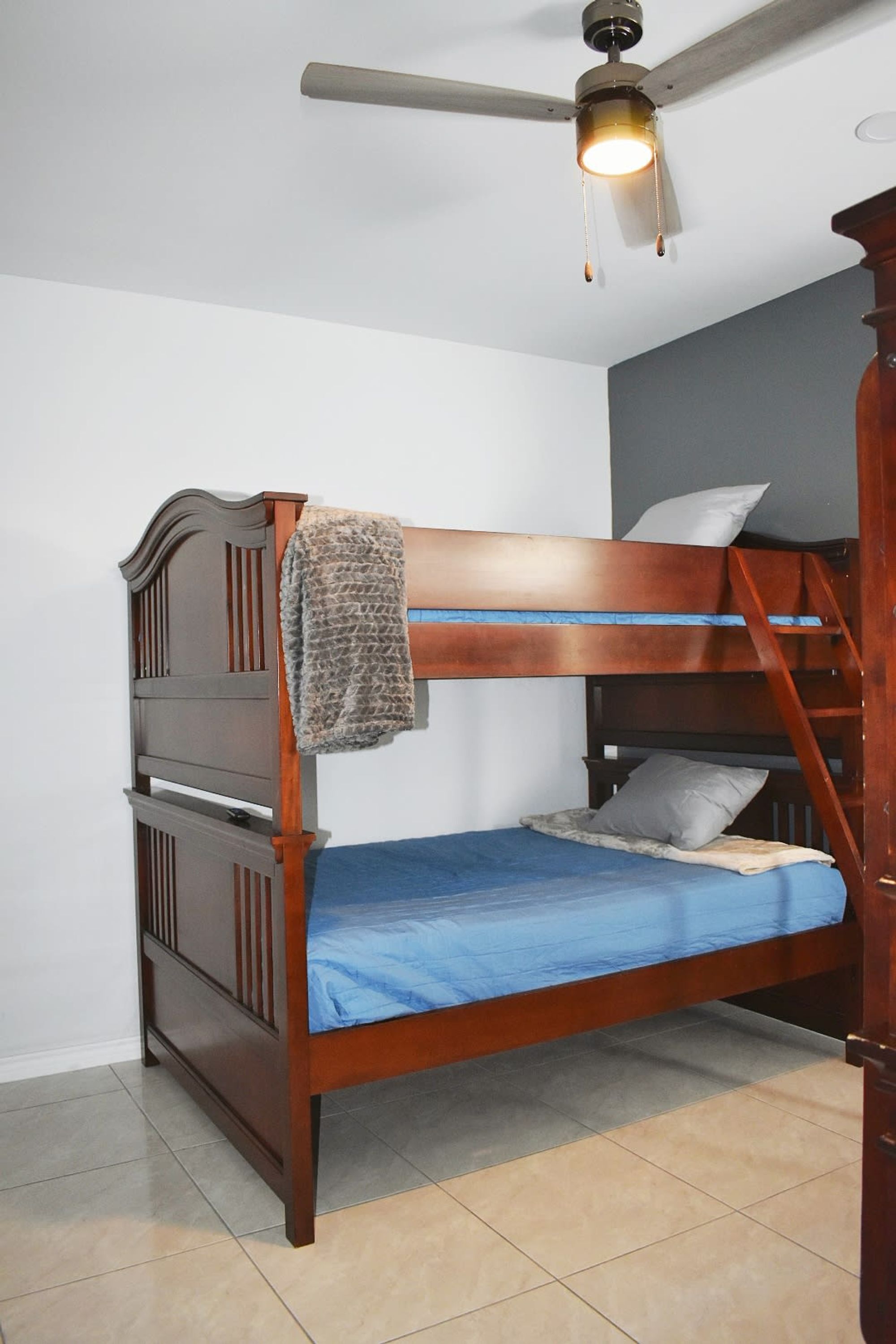A bunk bed with a ceiling fan and a light fixture.