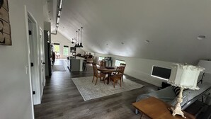 Tilava ullakkohuoneisto, jossa on keittiö, ruokailutila ja suuri ikkuna.