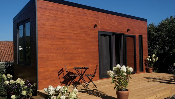 A modern wooden building with a deck, outdoor seating, and potted plants. - Quinta da Quinhas (Caminha)