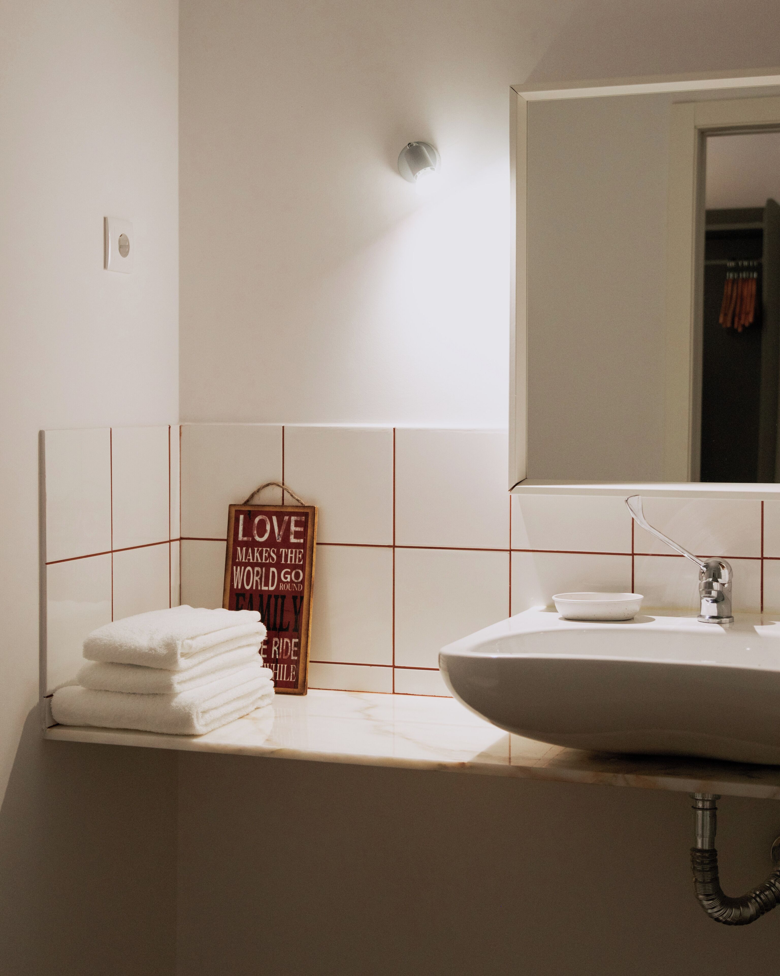 A bathroom with a white sink, a mirror, and a towel rack.