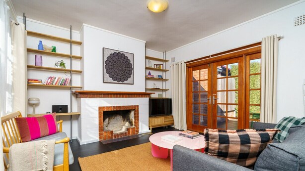 Ein Wohnzimmer mit Kamin, einer Couch, einem Couchtisch und einem Bücherregal.