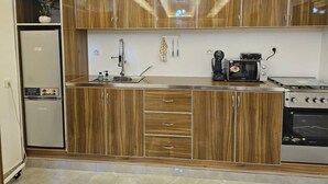 A modern kitchen with wooden cabinets, a built-in oven, and a coffee maker. - Appartement / Condominium de 3 Chambres et 3 Salles de Bain (Mamelles)