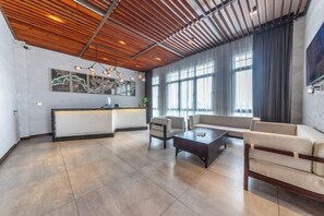 Un amplio espacio habitable con una cocina moderna, ventanas grandes y un techo alto con vigas de madera.