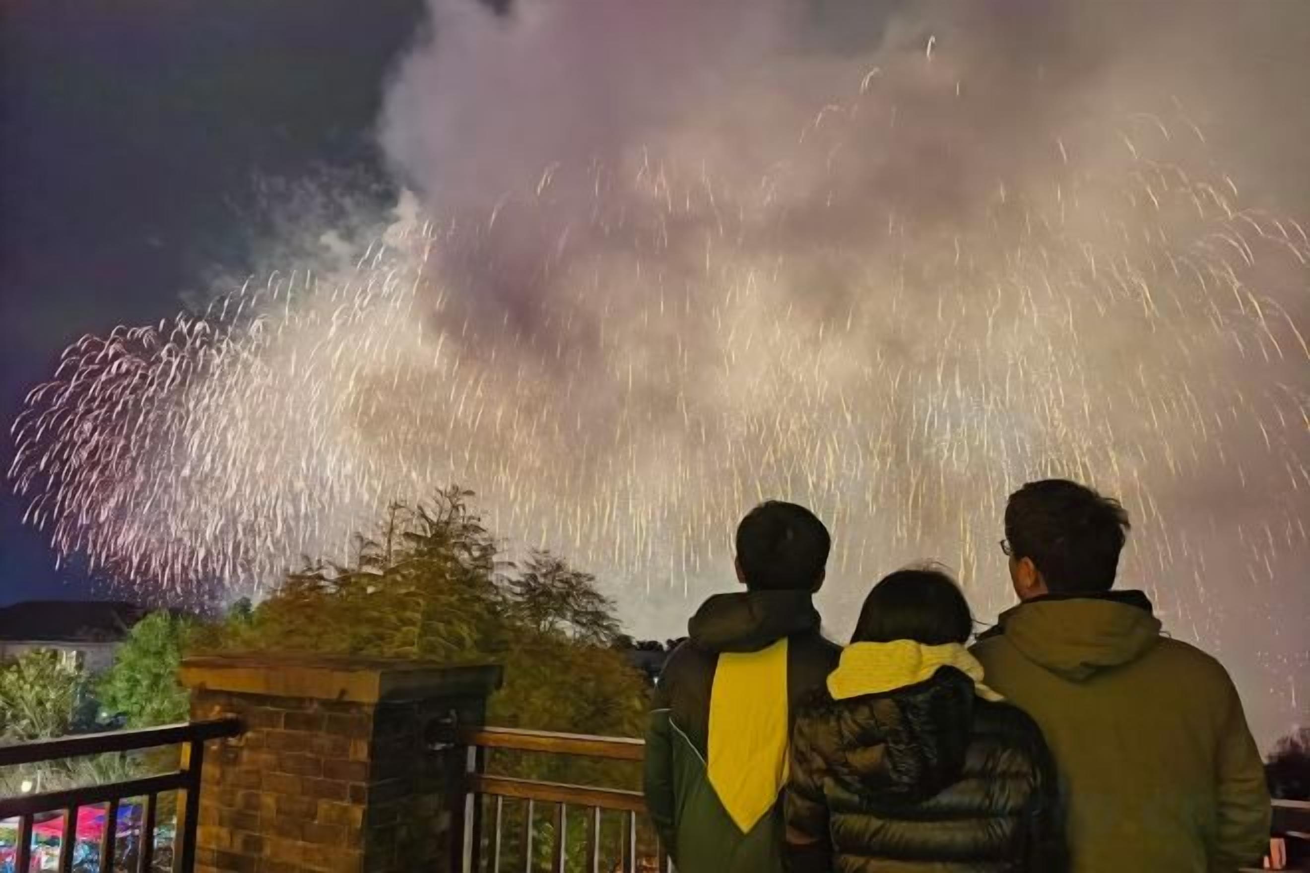 Um grupo de pessoas observando fogos de artifício.