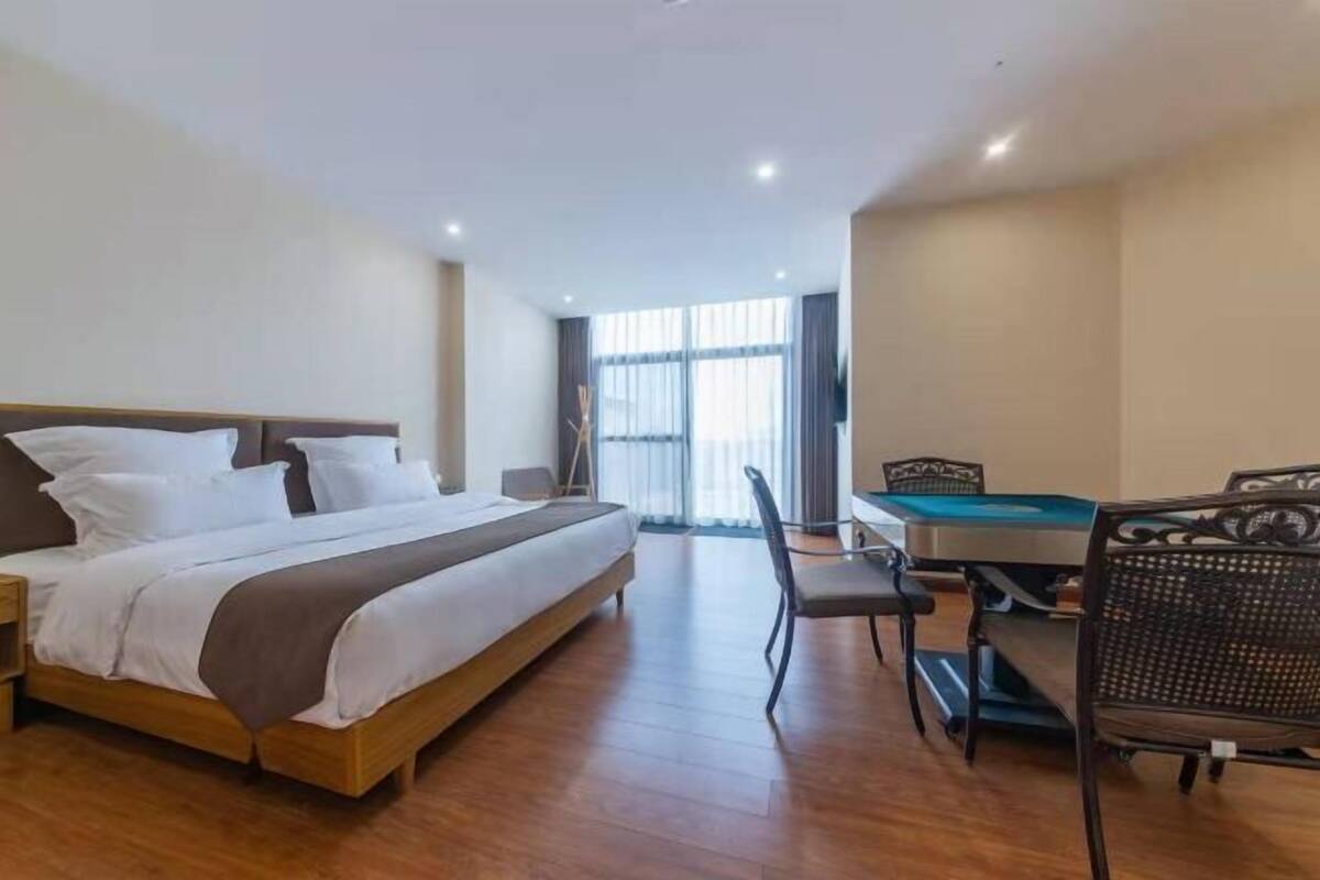 A hotel room with a bed, a pool table, and a view of the outdoors.