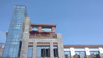 Un edificio de varios pisos con fachada de vidrio y tejado rojo.