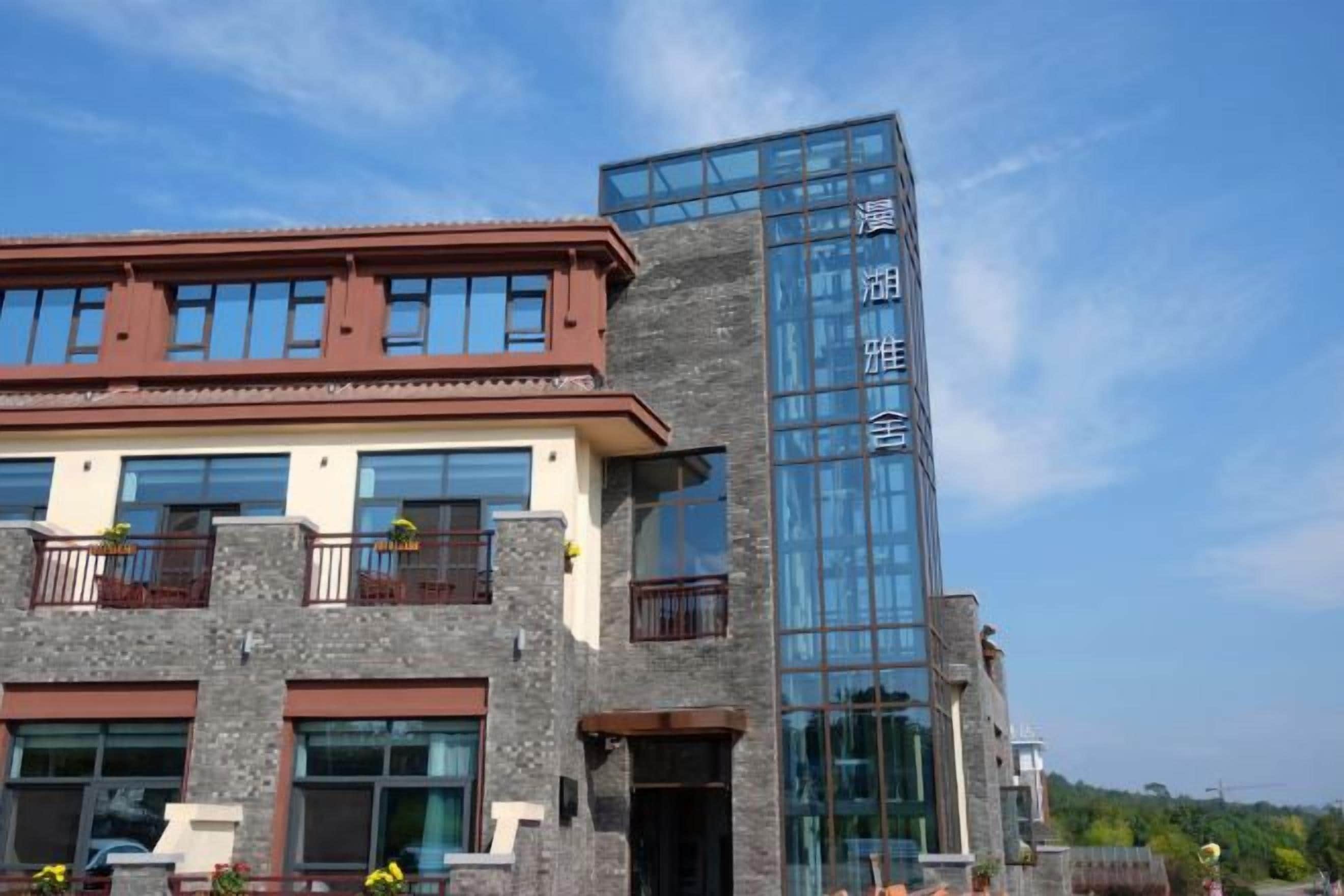 A building with a modern architectural design, featuring a mix of stone and glass materials.