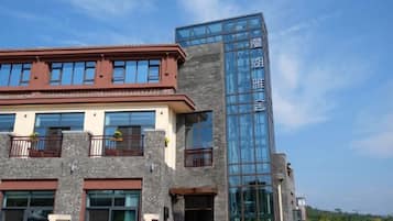 A building with a modern architectural design, featuring a mix of stone and glass materials.