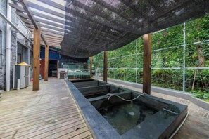 A spa area with wooden flooring, a covered seating area, and a view of greenery outside. - Changshou Manhu Yashe Hotel (Chongqing)