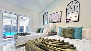 A bedroom with two beds, a large window, and a view of a swimming pool. - Miami house, Heated pool, Artificial beach, Mini golf, luxury and comfort (MIAMI)