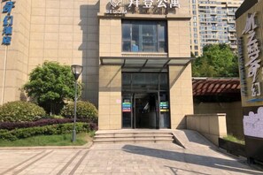 A building entrance with a glass door, steps leading up to it, and a sign above the door. - Bedom Apartment (Hengdian Nanjiang No. 1 Branch) (Dongyang)