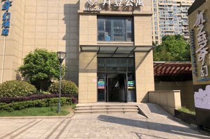 Entrada de un edificio con puerta de vidrio, escalones que conducen a ella y un cartel sobre la puerta.