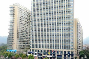 A multi-story building with a grid-like facade, likely a hotel or office building, with multiple floors and a uniform window pattern.