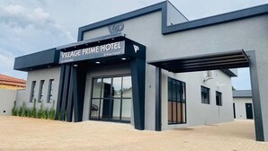 Ein modernes Gebäude mit einem Schild für das Village Prime Hotel.