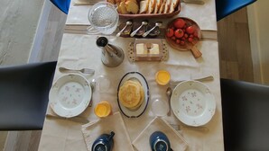 Une table de petit-déjeuner avec des assiettes, des tasses et une variété d’aliments.