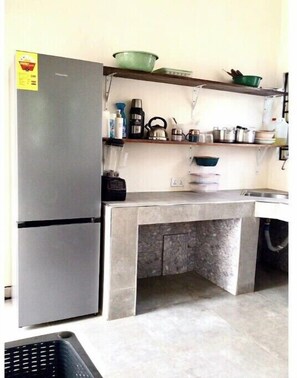 Enjoy cooking in this fully equipped kitchen with a refrigerator, kettle, coffee maker, and storage cabinets.
