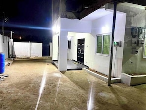 Experience the serene ambiance of this residence at night, with a well-lit entrance and inviting door.