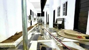 Un couloir doté d’un sol à motifs, de murs blancs et d’une colonne centrale.