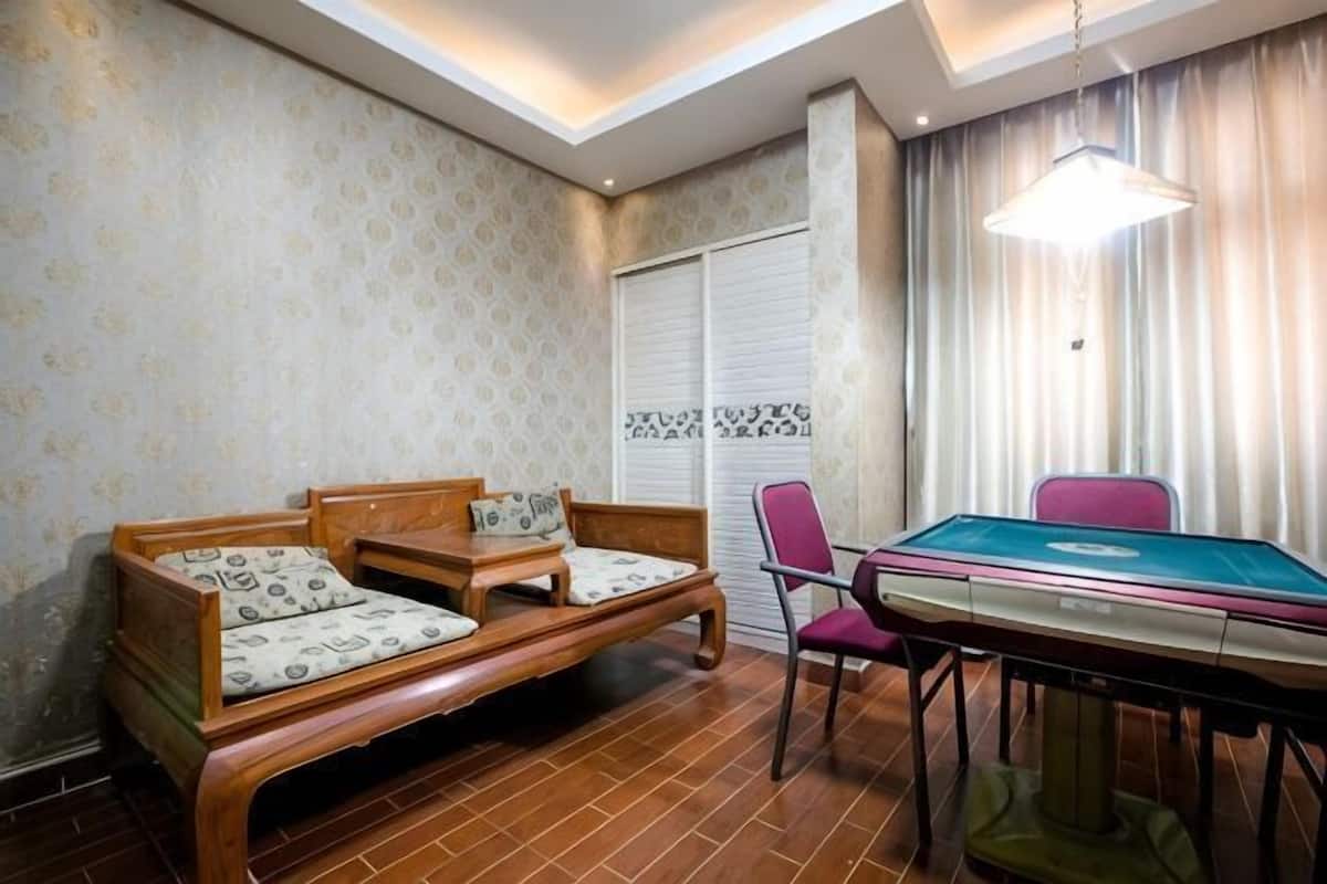 Una habitación con un sofá de madera, una mesa de billar y una silla.
