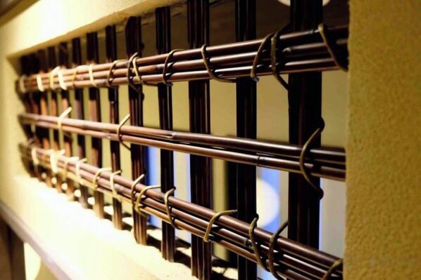A series of vertical blinds with a metallic finish, attached to a wall.