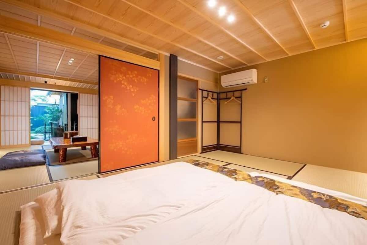 A traditional Japanese-style room with tatami flooring, a bed, a sliding door, and a wardrobe.
