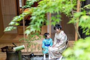 A traditional Japanese interior with tatami flooring, a wooden structure, and a small garden area. - Hiyori Gojo (Kyoto)