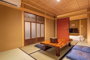 A traditional Japanese room with tatami flooring, a wooden table, and shoji screens. - Hiyori Gojo (Kyoto)