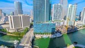A modern cityscape with high-rise buildings, a waterfront promenade, and a bridge. - Icon Brickell - Panoramic Views - Spa Access (Miami)