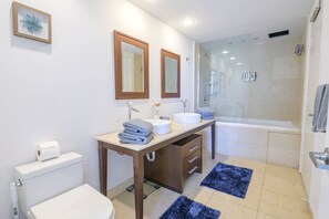 Ein Badezimmer mit Toilette, Waschbecken, Spiegel und Dusche.