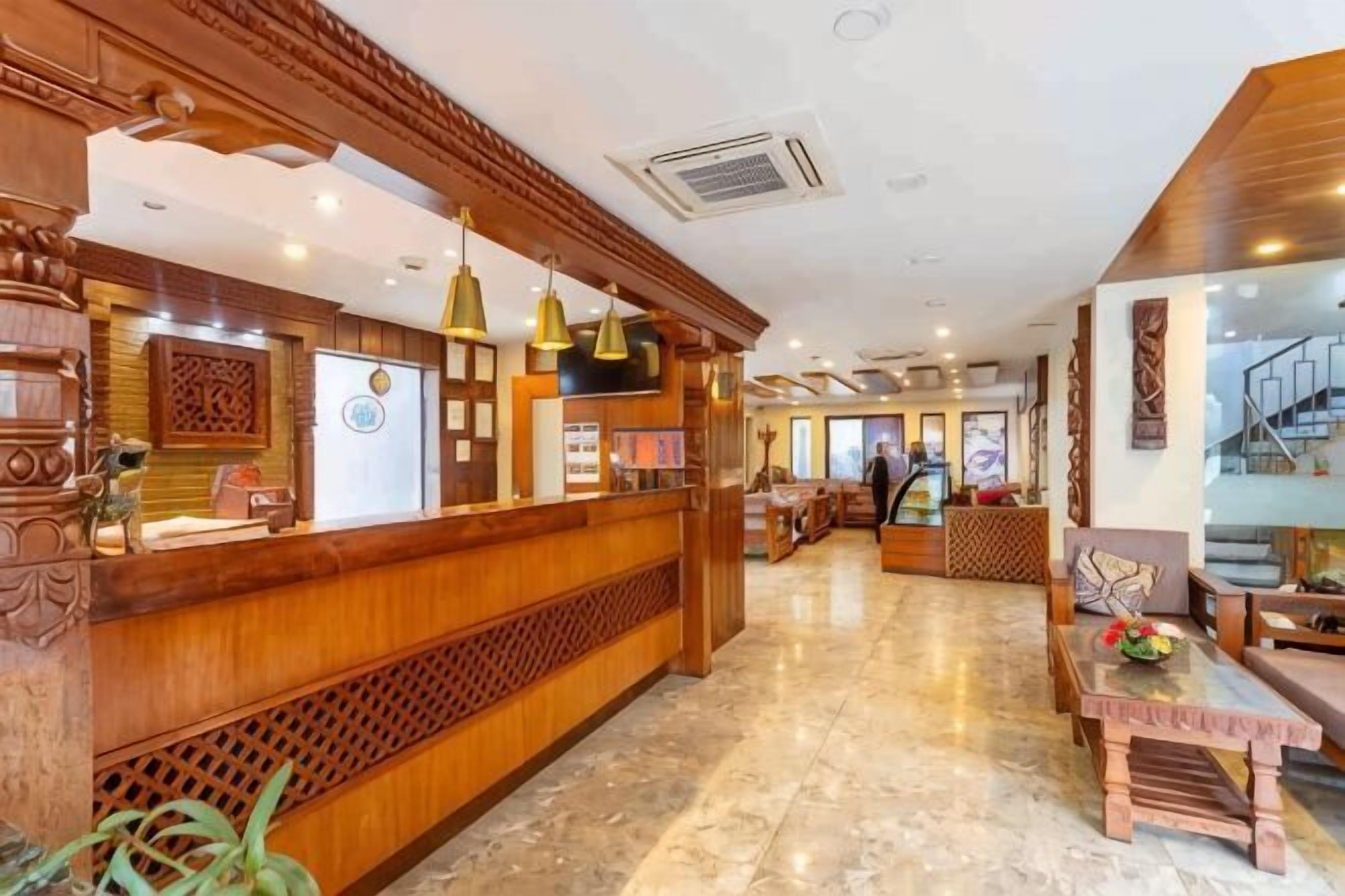 A reception area with a wooden reception desk, pendant lighting, and a marble floor.
