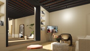 Un salon moderne doté d’un grand miroir, d’un téléviseur et d’un coin salon confortable.